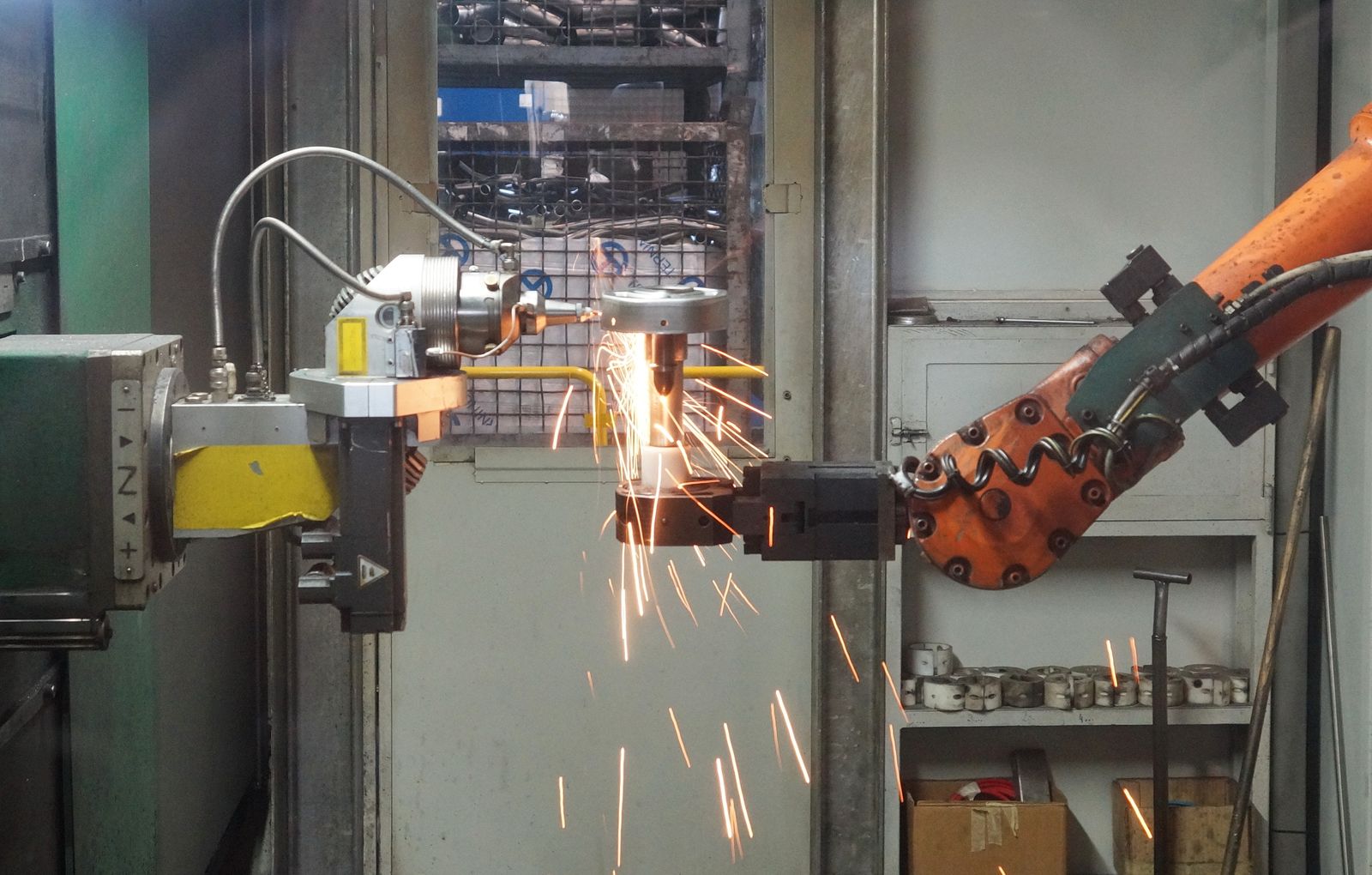 Industrial robotic arm working metal with bright sparks