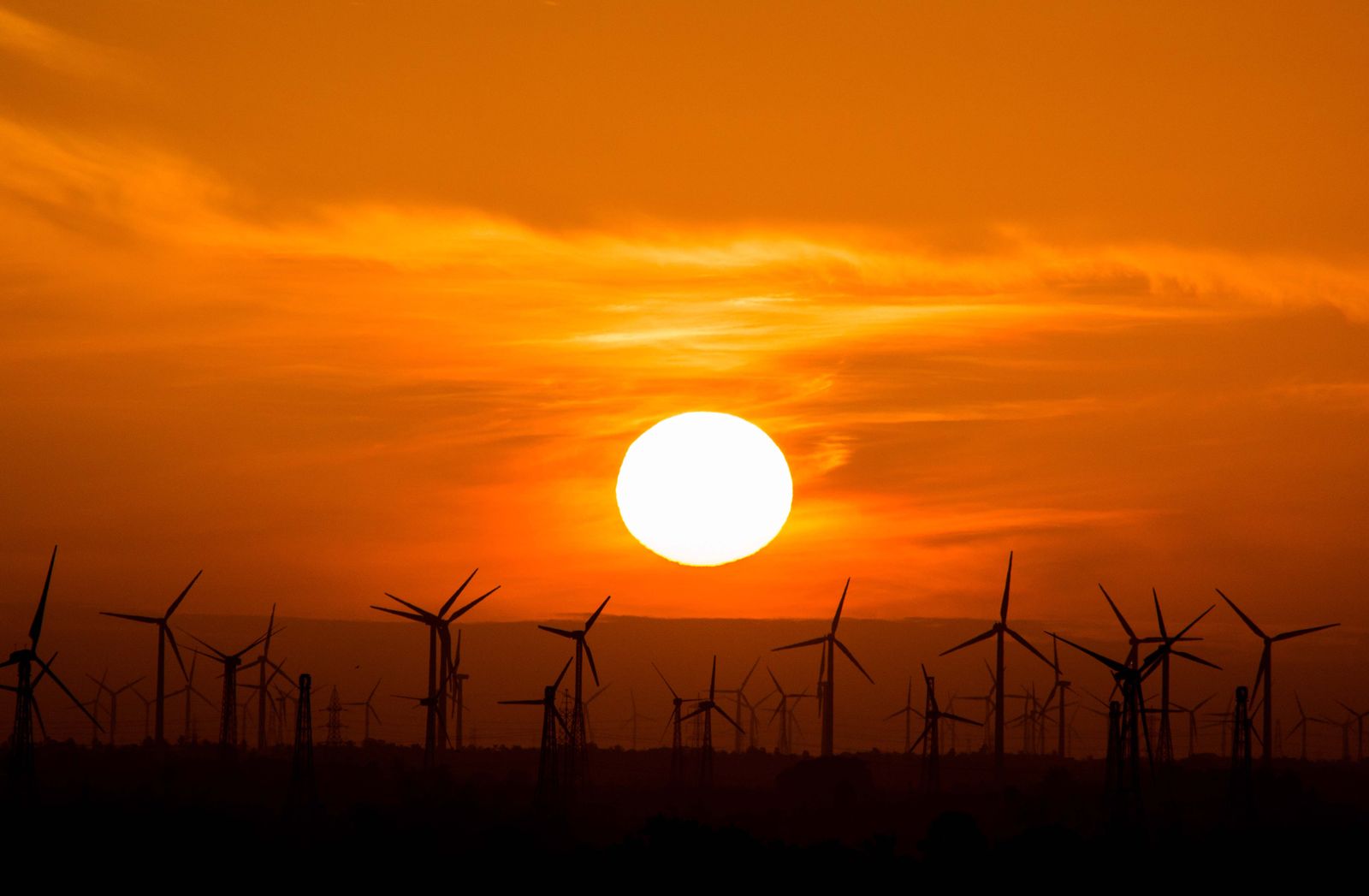 Wind turbines silhouetted against the sunset