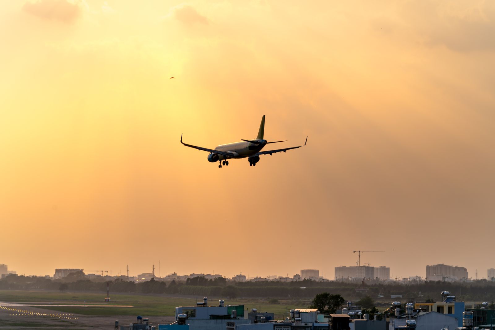 Aircraft approaching a runway against a dusk sky